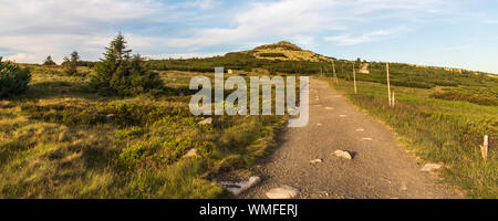 Rocky Violik Hügel mit Wanderweg und Gebäude auf Snezne jamy auf dem Hintergrund in Abend Riesengebirge auf tschechisch-polnischen Grenzen Stockfoto