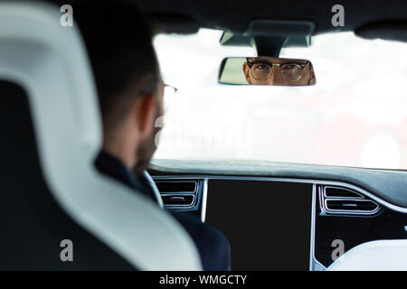 Schöner mann Brille in den Rückspiegel schauen, Stockfoto
