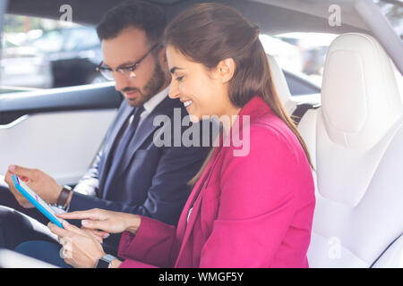 Paar Geschäftsmänner mit Tablette während der Sitzung in die Katze Stockfoto