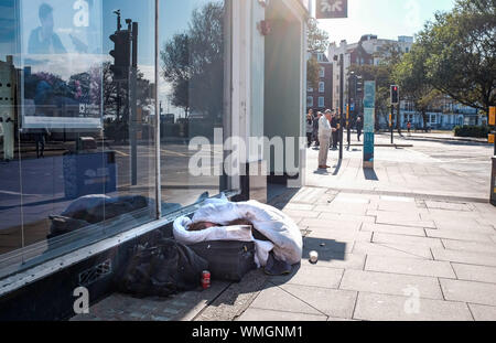 Brighton, Großbritannien - 5. September 2019 einen Obdachlosen Paar huddle zusammen auf dem Bürgersteig in Brighton City Centre weltvergessen zu den sonnigen Tag wie im Südosten von England weiterhin warmen sonnigen Wetter zu genießen. Foto: Simon Dack/Alamy leben Nachrichten Stockfoto