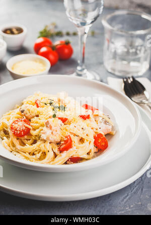 Leckere Pasta Linguine mit cremiger Lachs und Tomaten. Spaghetti Pasta mit Kräutern und frischen Lachs Stockfoto