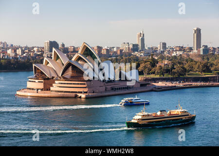 Fähren im Hafen von Sydney mit Sydney Skyline und Sydney Opera House im Hintergrund. Von Sydney Harbour Bridge. Sonnigen morgen. Stockfoto