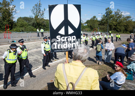 London, Großbritannien. 4. September, 2019. Die Metropolitan Police Officers Form ein Cordon um Anti-AKW-Aktivistinnen außerhalb ExCel London protestieren am dritten Tag eines einwöchigen Karneval der Widerstand gegen DSEI, der größten Waffen der Welt. Die Proteste der dritten Tag wurden von der Kampagne für Nukleare Abrüstung (CND) und Trident Ploughshares organisiert. Credit: Mark Kerrison/Alamy leben Nachrichten Stockfoto