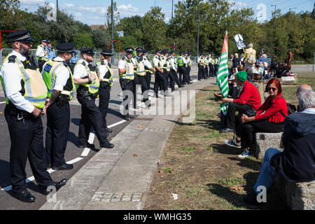 London, Großbritannien. 4. September, 2019. Die Metropolitan Police Officers Form ein Cordon um Anti-AKW-Aktivistinnen außerhalb ExCel London protestieren am dritten Tag eines einwöchigen Karneval der Widerstand gegen DSEI, der größten Waffen der Welt. Die Proteste der dritten Tag wurden von der Kampagne für Nukleare Abrüstung (CND) und Trident Ploughshares organisiert. Credit: Mark Kerrison/Alamy leben Nachrichten Stockfoto