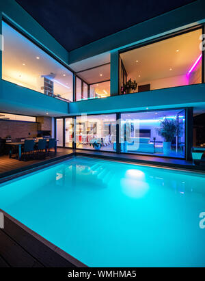 Moderne Villa mit farbigen LED-Lichter in der Nacht. Niemand im Inneren Stockfoto