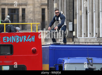 Ein Stuntman springt von einem offenen Bus auf einen Van auf Waterloo Place in Edinburgh, während der Proben für die Dreharbeiten von Schnell und wütend 9. Stockfoto