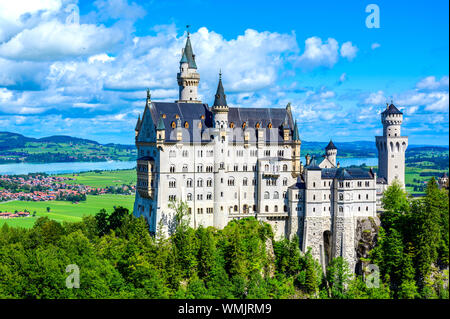 Schloss Neuschwanstein in der schönen Berglandschaft der Alpen - Im Hintergrund sieht man den Forggensee - in der Nähe von Füssen, Bayern, Deutschland Stockfoto