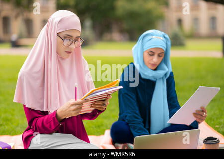 Schönen muslimischen Student trägt die Brille studieren mit Freund Stockfoto