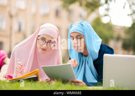 Zwei muslimische Studenten im hijab auf Lane und Lesen Stockfoto