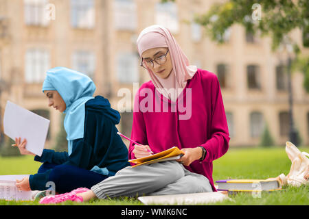 Muslimische Schüler Brille Studium hart in der Nähe von Freund Stockfoto