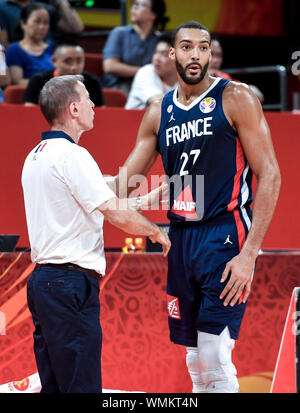 (190905) - Shenzhen, Sept. 5, 2019 (Xinhua) - Rudy Gobert (R) von Frankreich im Gespräch mit dem Head Coach Vincent Spannzange während der Gruppe G Übereinstimmung zwischen der Dominikanischen Republik und Frankreich an der FIBA WM 2019 in Shenzhen im Süden Chinas Provinz Guangdong, Sept. 5, 2019. (Xinhua / Xu Chang) Stockfoto