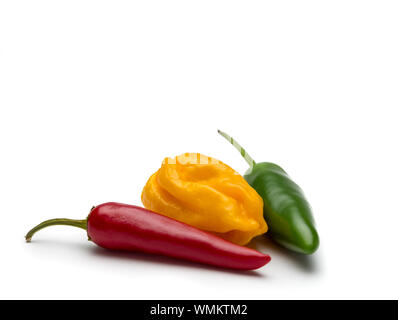 Drei Paprika verschiedener Form und Farbe auf weißem Hintergrund. Selektive konzentrieren. Stockfoto