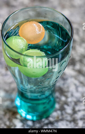 Coca Cola Glas mit bunten Ice Cube, stehend auf einem Granit Plattform. Hohen Winkel anzeigen, schließen. Stockfoto