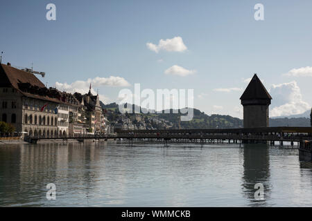 Blick auf die Kapellenbrücke, den Reuss, die Gebäude unter der Egg und die Berge hinter dem See in Luzern, Schweiz. Stockfoto