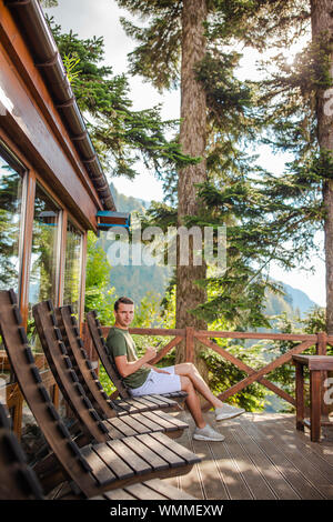 Junge Mann in den Bergen in die fantastische Natur Restaurant mit schöner Aussicht auf die Sommerferien. Wunderschöne Landschaft Stockfoto