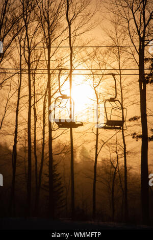 Silhouette eines leeren Triple ski Sessellift gegen eine große Rising Sun, Stowe, Vermont, USA Stockfoto