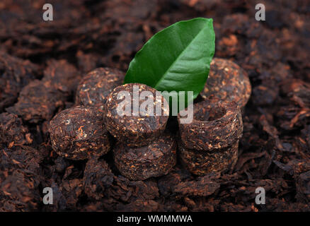 Aromatische schwarz pu-erh Tee. Fermentiert und Laub in Ziegeln verdichtet. Runde, flache Scheibe des puer Tee. Gesundes Getränk. Stockfoto