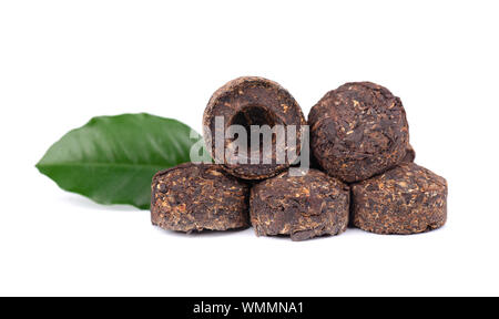 Aromatische schwarz pu-erh Tee, auf weißem Hintergrund. Close Up. Fermentiert und Laub in Ziegeln verdichtet. Runde, flache Scheibe des puer Tee. Gesund Stockfoto