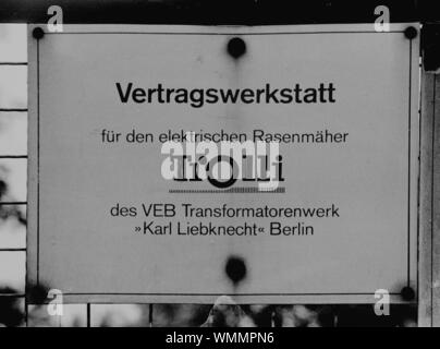 01. Januar 1990, Berlin, Angermünde: Brandenburg/DDR/1990 Zeichen an einem Workshop in Angermuende. Es zeigt die Organisation der DDR-Wirtschaft. Die Mähdrescher wurden verpflichtet, 5 % des Umsatzes als Konsumgüter zu produzieren, um die Bevölkerung besser zu dienen. Sie hatte deshalb auch Netzwerke zu setzen. - Lawnmaeher Trolli, VEB Transformatorenwerk Karl-Liebknecht Berlin. Foto: Paul Glaser/dpa-Zentralbild/ZB Stockfoto