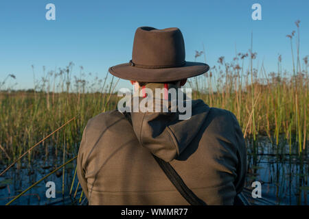 Junger Mann in einer traditionellen Einbaum sitzen in der Mitte der Rohre Stockfoto