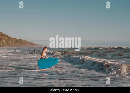 Junge mit Boogie Board am Strand Stockfoto