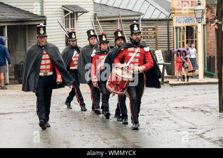 Eine Abteilung der britischen Soldaten der Regierung Kräfte, marschieren die Hauptstraße im Sovereign Hill open-air-Museum in der Vorstadt von Balla Stockfoto