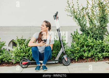 Frau sitzt auf dem Motorroller. Stockfoto