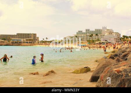 Maho Beach, Sint Maarten - am 19. August 2019: Touristen und Urlauber im Meer und auf dem Sand entspannen, an Maho Beach, St. Maarten. Stockfoto