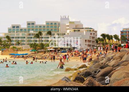 Maho Beach, Sint Maarten - am 19. August 2019: Touristen und Urlauber im Meer und auf dem Sand entspannen, an Maho Beach, St. Maarten. Stockfoto