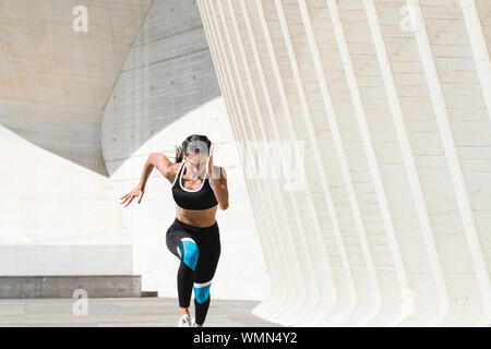 Oberkörper von weiblichen Athleten in Sportkleidung schnell auf Beton Stockfoto