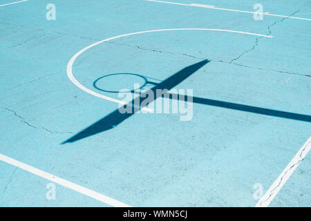 Schatten von einem Basketballkorb auf bunten Hof Stockfoto