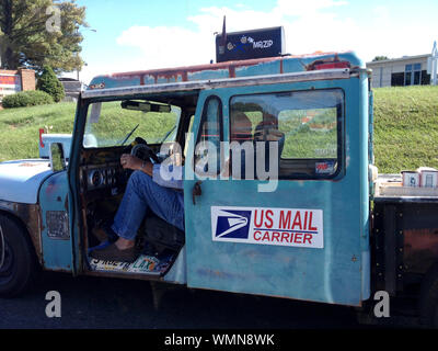 USPS Arbeiter liefert die E-Mail von einem alten Lastwagen in den ländlichen USA. Stockfoto