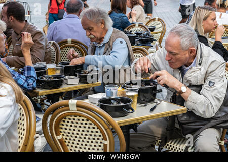 Lille, Frankreich - September 01,2019: Große Lille Braderie (Braderie de Lille). Glückliche Menschen essen traditionelles Gericht auf Lille Braderie, Muscheln und Pommes frites. Stockfoto