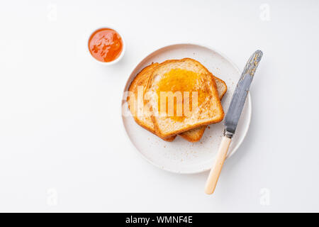 Morgen Toast mit Butter und Marmelade auf weißen Tisch Stockfoto
