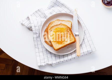 Morgen Toast mit Butter und Marmelade auf weißen Tisch Stockfoto