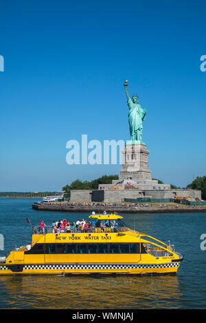 New York City - Touristen die Freiheitsstatue bewundern Sie von der Yellow Water Taxi am Hudson River. Stockfoto