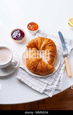 Ansicht von oben flatlay mit frischen Croissants mit Marmelade, Kaffee und buter. Morgen Mahlzeit Konzept. Weißer Hintergrund Stockfoto