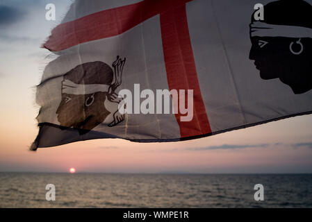 Sardische Flagge (die Flagge der vier Mauren genannt) in der Nähe von Mittelmeer in Lu Bagnu, Provinz Sassari, Sardinien, Italien. Stockfoto