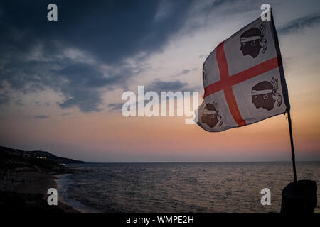 Sardische Flagge (die Flagge der vier Mauren genannt) in der Nähe von Mittelmeer in Lu Bagnu, Provinz Sassari, Sardinien, Italien. Stockfoto