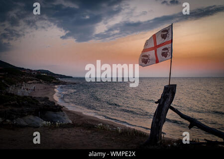 Sardische Flagge (die Flagge der vier Mauren genannt) in der Nähe von Mittelmeer in Lu Bagnu, Provinz Sassari, Sardinien, Italien. Stockfoto