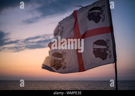 Sardische Flagge (die Flagge der vier Mauren genannt) in der Nähe von Mittelmeer in Lu Bagnu, Provinz Sassari, Sardinien, Italien. Stockfoto