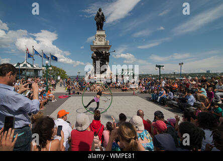 Weibliche Acrobat, Street Performer, spielt eine große Menschenmenge an einem sommerlichen Nachmittag auf der Terrasse Dufferin im Zentrum von Quebec, CA. Stockfoto