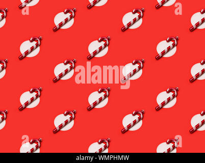 Nahtlose Muster mit weißen Weihnachten Zuckerstange Ornamenten über den roten Hintergrund Stockfoto