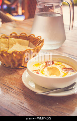 Hummus pürierte Kichererbsen, Tahini, Zitrone, Knoblauch beträufelt mit extra natives Öl mit Fladenbrot serviert. Stockfoto