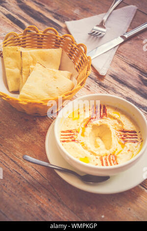 Hummus pürierte Kichererbsen, Tahini, Zitrone, Knoblauch beträufelt mit extra natives Öl mit Fladenbrot serviert. Stockfoto