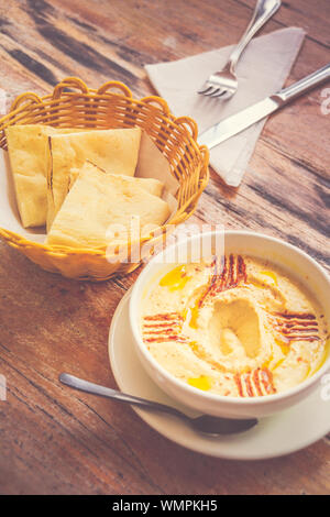 Hummus pürierte Kichererbsen, Tahini, Zitrone, Knoblauch beträufelt mit extra natives Öl mit Fladenbrot serviert. Stockfoto