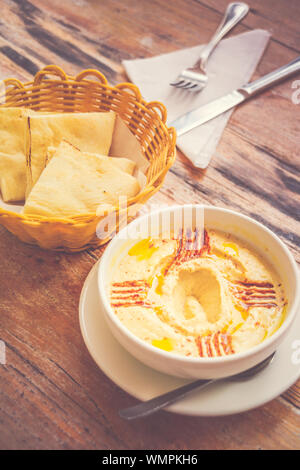 Hummus pürierte Kichererbsen, Tahini, Zitrone, Knoblauch beträufelt mit extra natives Öl mit Fladenbrot serviert. Stockfoto