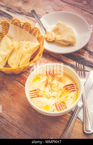 Hummus pürierte Kichererbsen, Tahini, Zitrone, Knoblauch beträufelt mit extra natives Öl mit Fladenbrot serviert. Stockfoto