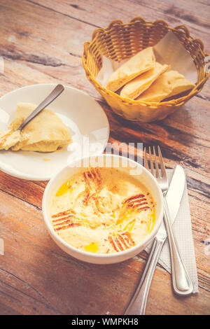 Hummus pürierte Kichererbsen, Tahini, Zitrone, Knoblauch beträufelt mit extra natives Öl mit Fladenbrot serviert. Stockfoto