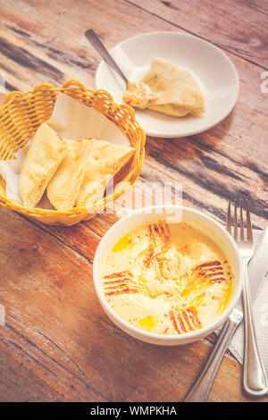 Hummus pürierte Kichererbsen, Tahini, Zitrone, Knoblauch beträufelt mit extra natives Öl mit Fladenbrot serviert. Stockfoto